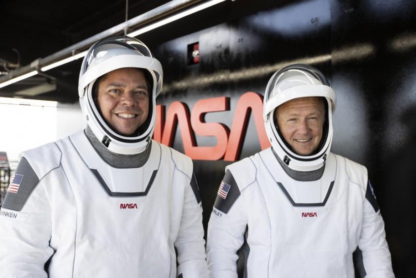 Астронавтите на NASA Боб Бенкен (вляво) и Дъг Хърли (вдясно) позират на кулата на стартовата площадка 39А по време на репетиция за изстрелването. 