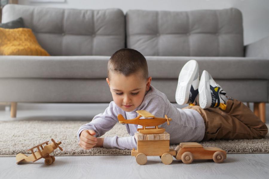 Дете играе с дървена играчка
